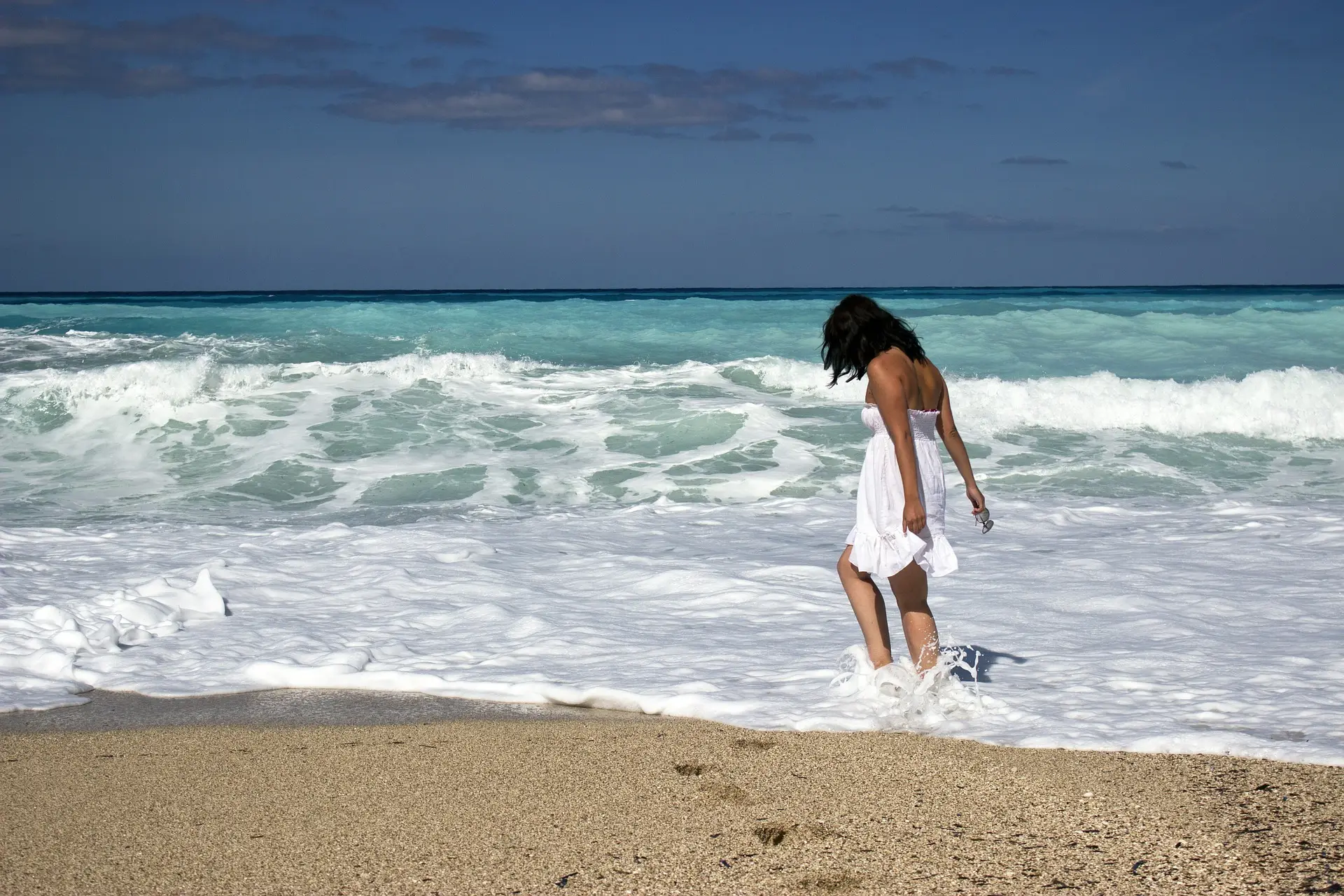 Woman walking on a tropical beach shoreline